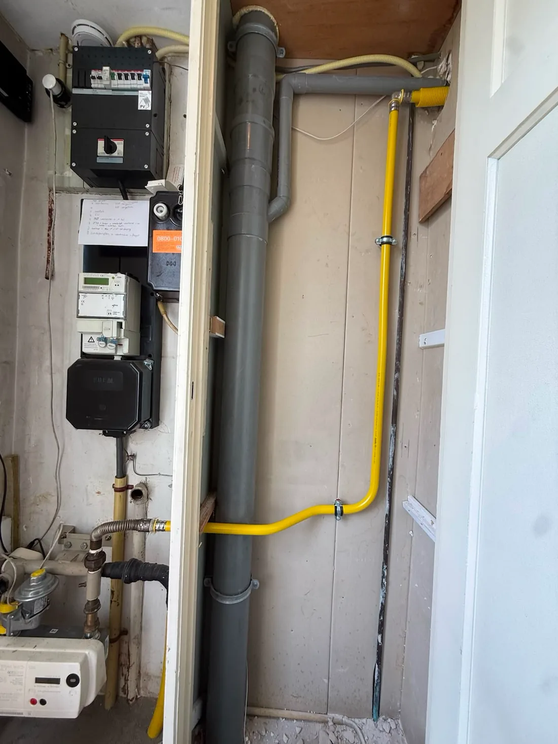 Nieuwe gele gasleiding loopt vanaf de gasmeter in de meterkast omhoog langs de wand